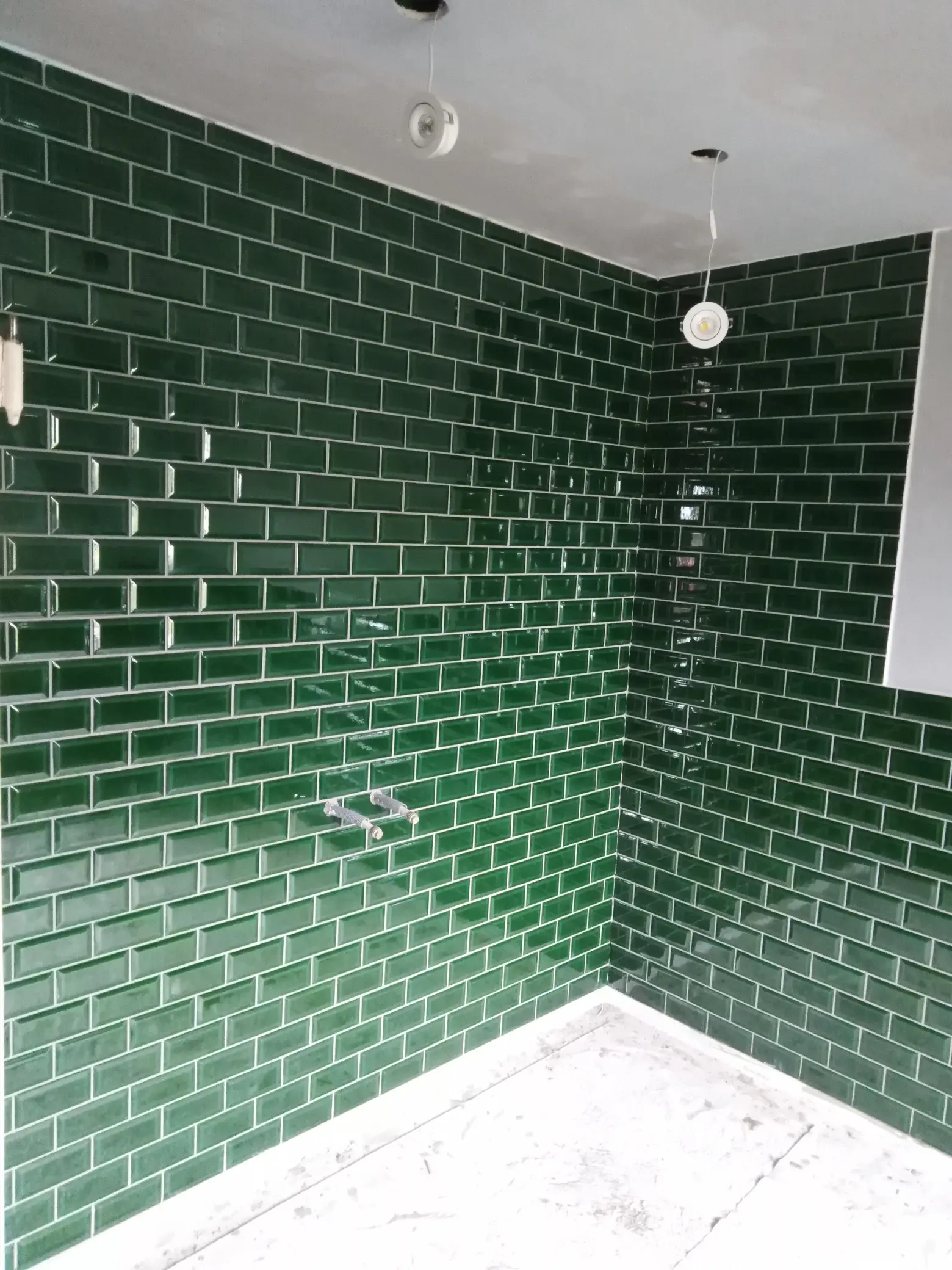 Badrumsrenovering med iögonfallande grönt glaserat tegelkakel i duschhörna, modern och karaktärsfull design.